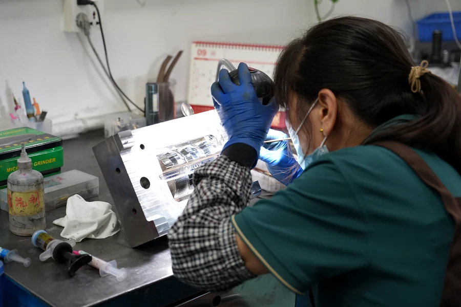 Technician manually fitting a mold component