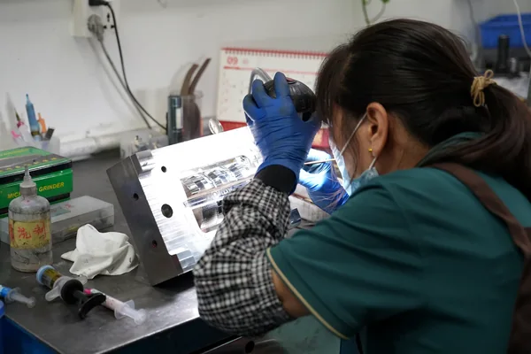 Technician manually fitting and finishing a mold component