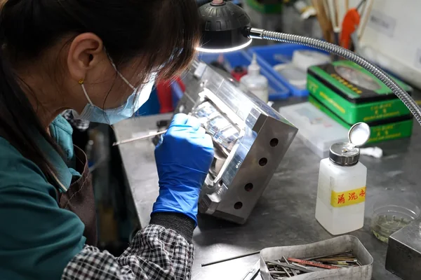 Technician polishing and assembling an injection mold
