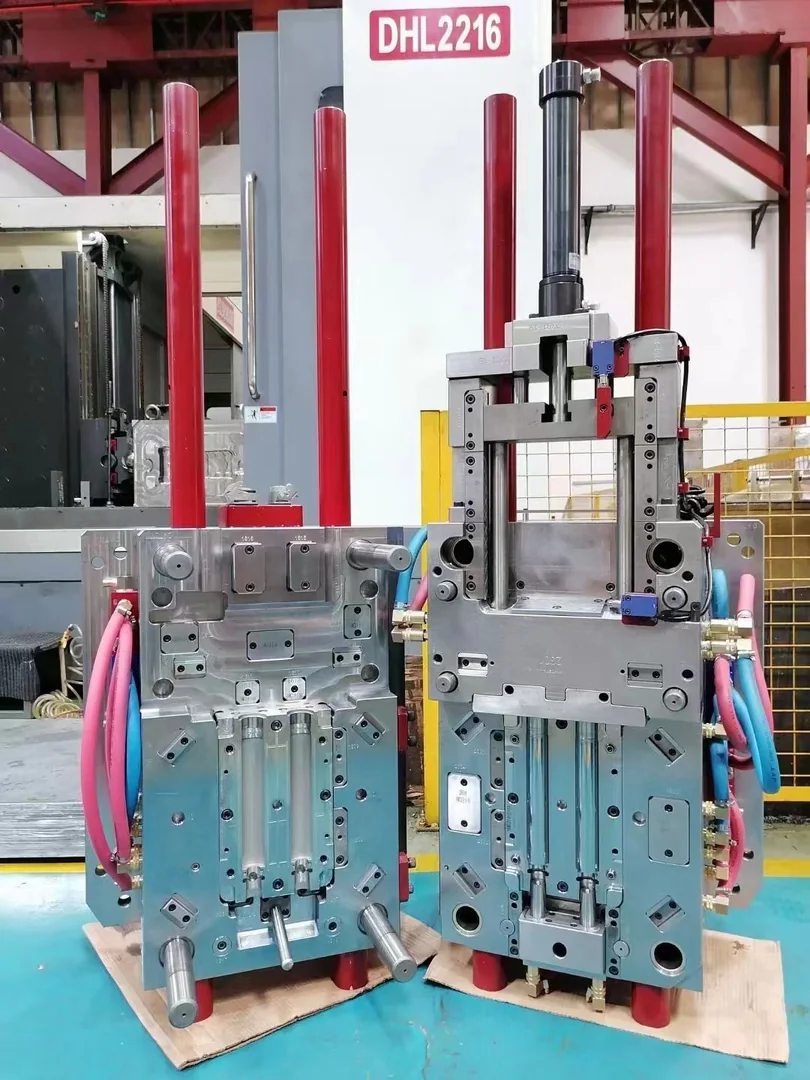 Open production injection mold displayed beside a molding machine
