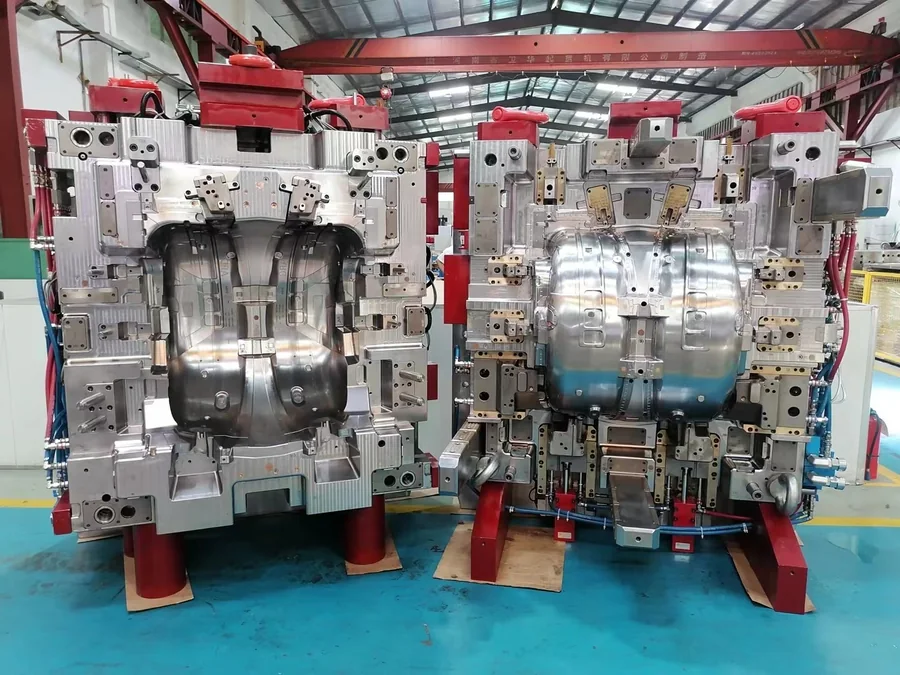 Large open injection mold displayed on the factory floor